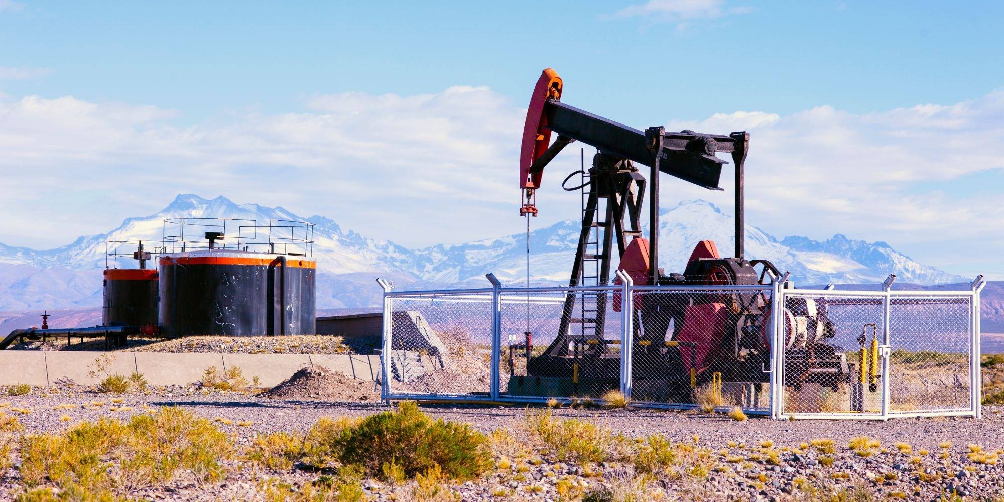 A pump jack at an oil field with mountains in the background, representing remote industries that rely on remote medical services
