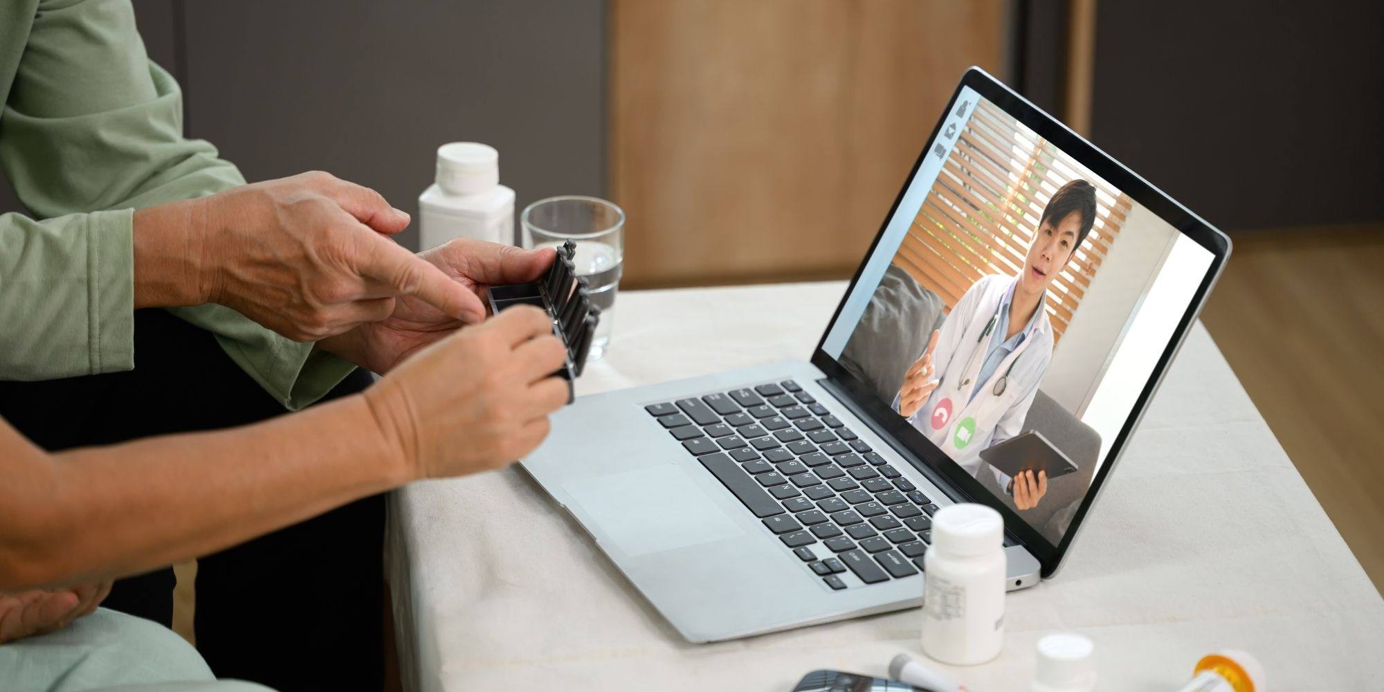 A patient on a video call with a doctor from a laptop, representing telehealth and remote medical services
