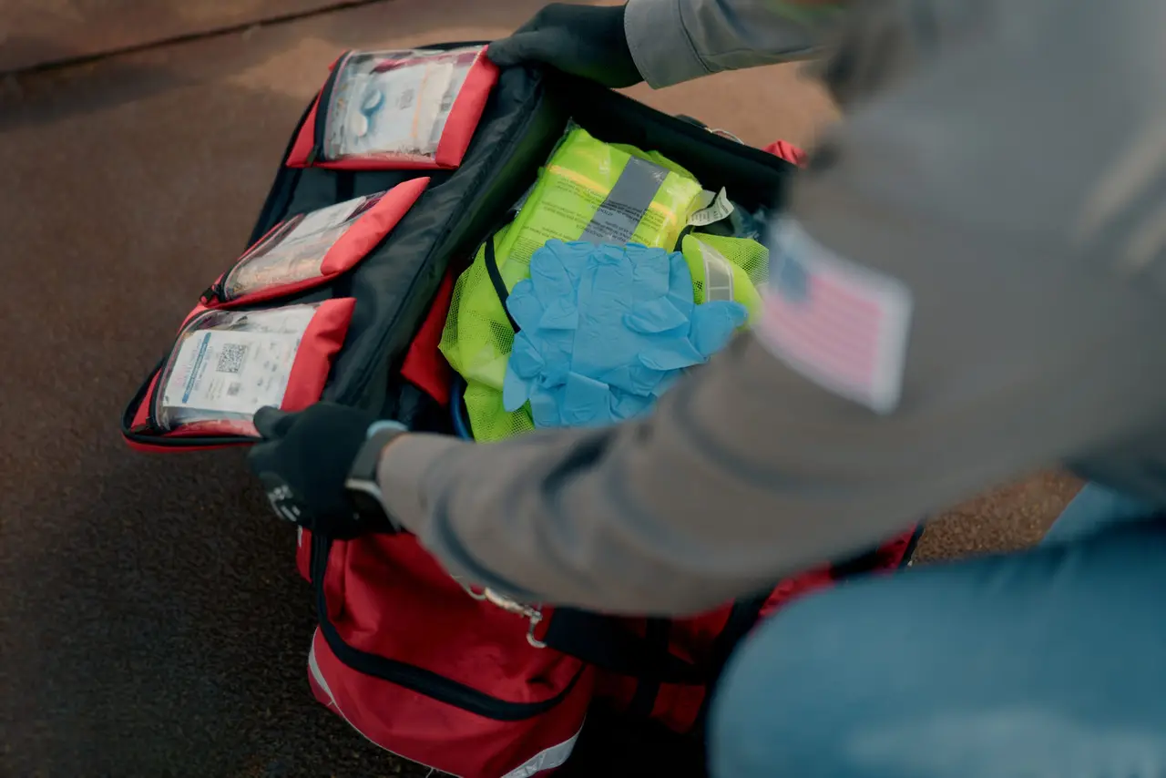 A medic checking a stocked medical response bag with supplies and PPE