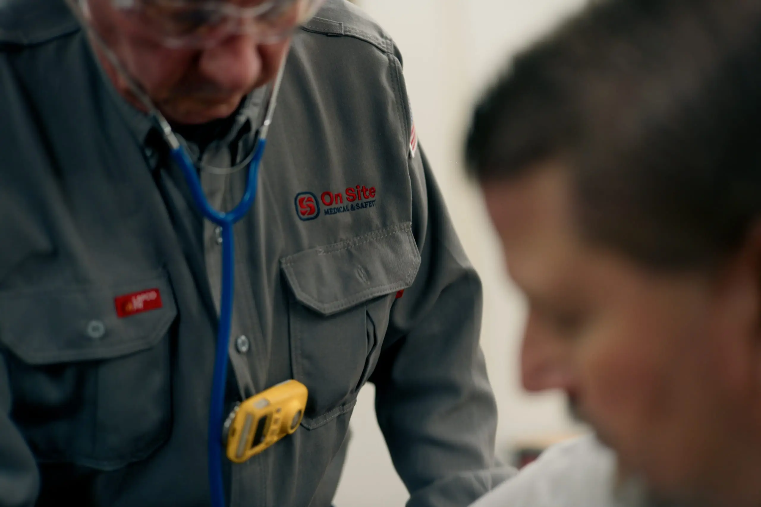 An On Site medic with a stethoscope assessing a worker under physician-directed protocols